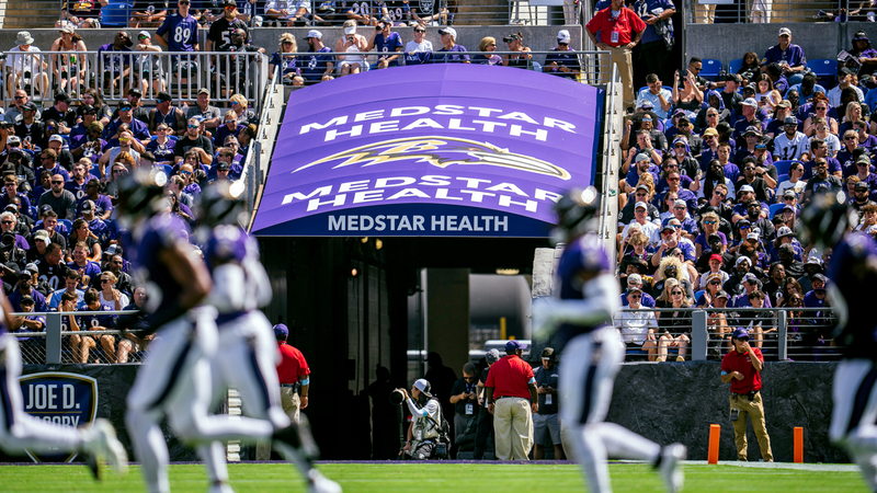 MedStar Health sign with football players in the foreground during a Baltimore Ravens game at M&T Bank Stadium.