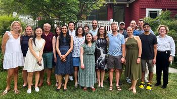 A group of faculty members gathers for a casual group photo outdoors.