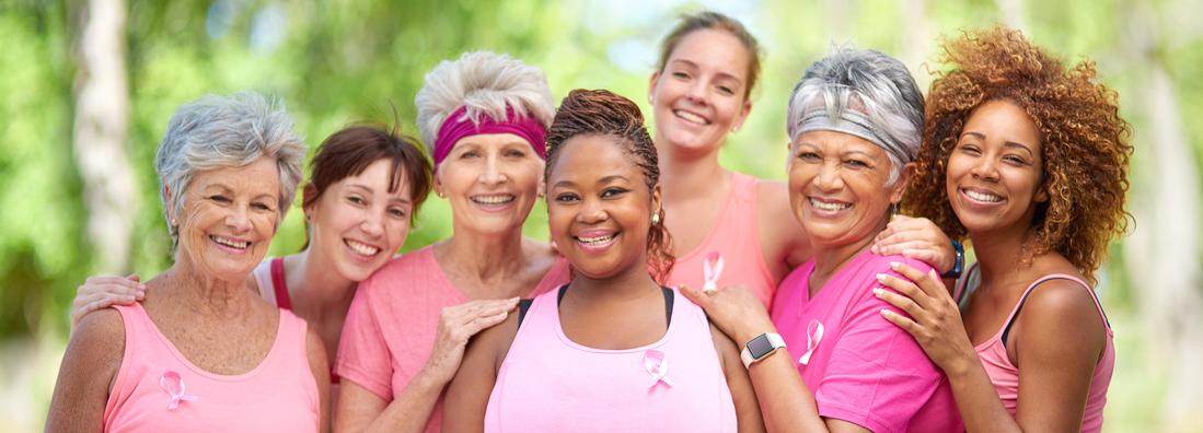 Portrait of a group of women, all wearing pink, taking part in a fitness event to raise awareness for breast cancer