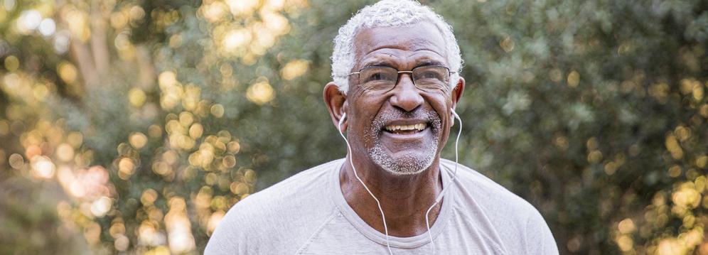 A senior african american man wearing headphones during a workout outdoors.