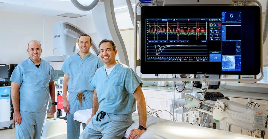Doctors Itsik Ben-Dor, Brian Case and Hayder Hashim pose for a team photo in the cardiac catheterization lab at MedStar Washington Hospital Center.