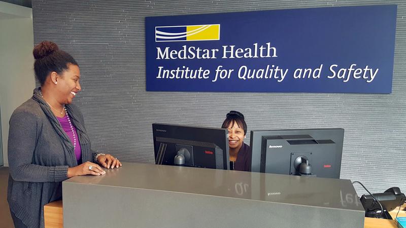 Two associates at the front desk for MedStar Health's Institute for Quality and Safety.