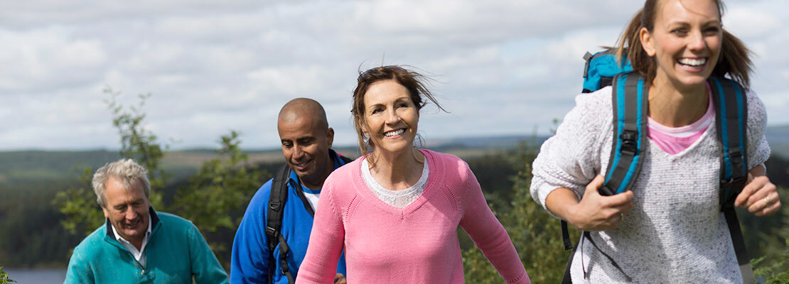 A multi-generational family hikes in the mountains.