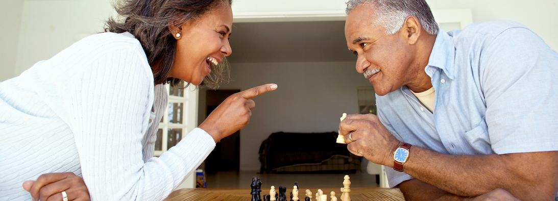 Side view of husband and wife playing chess