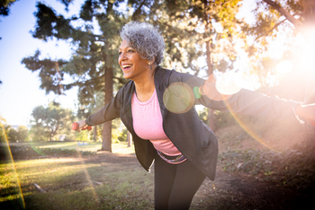 A mature african-american woman uses weights during her workout.