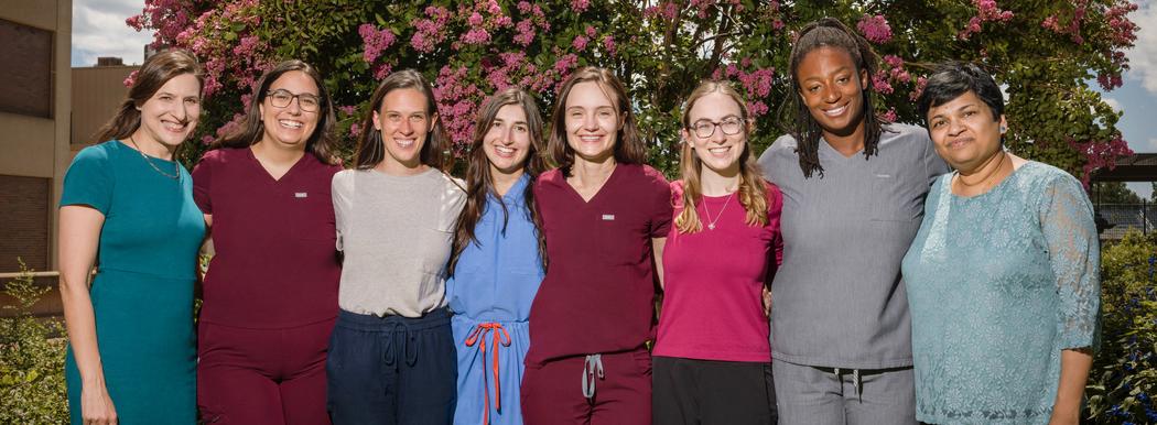 A group of fellows from MedStar Health's Neonatal Perinatal Medicine Fellowship program pose for a group photo outdoors under a tree.