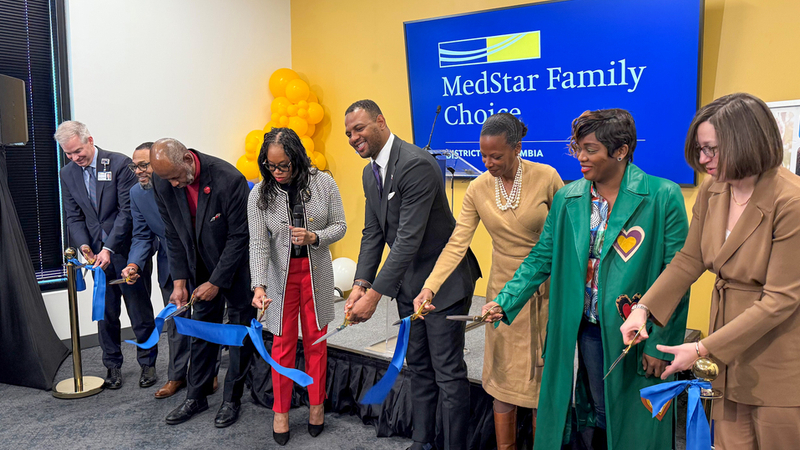 A group of people cut the ribbon at a ceremony to celebrate the opening of a new MedStar Family Choice wellness center in Ward 7 in Washington DC.