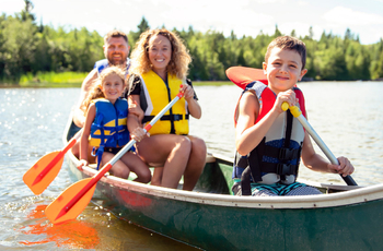A family has fun kayaking together on a lake outdoors.