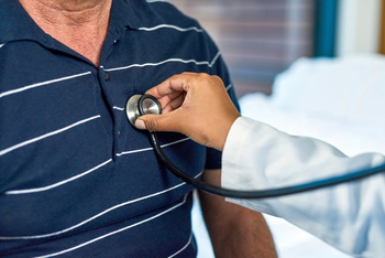 Close up photo of a doctor using a stethoscope listening to a patient's heart.