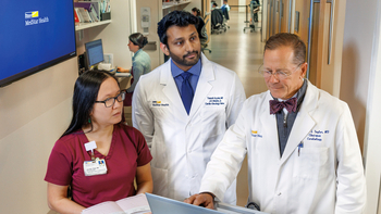 Dr. Allen Taylor talks with fellows in a hallway at MedStar Health.