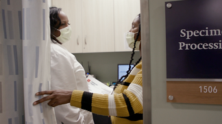 A doctor talks with a colleague in a specimen pricessing room at MedStar Health.