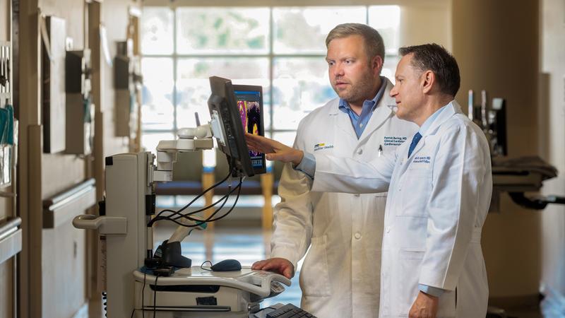 Doctors Patrick Bering and Mark Hofmeyer look at imaging in a hospital hallway at MedStar Health.