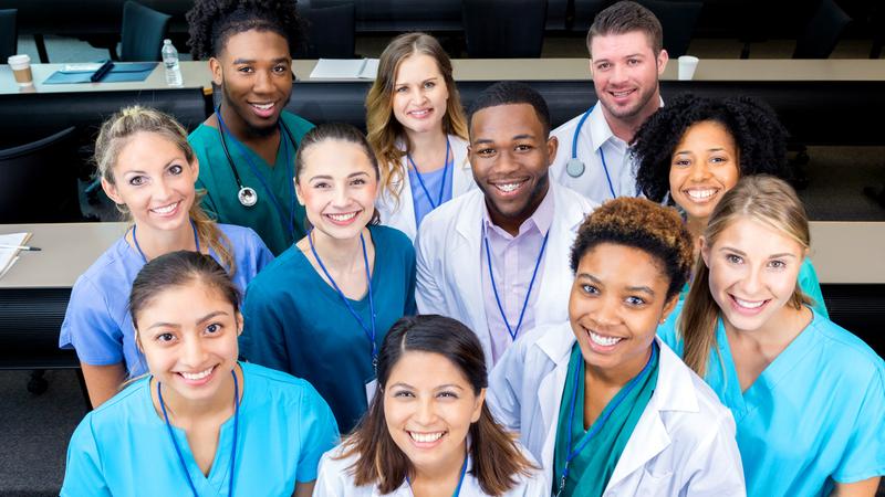 A diverse group of healthcare professionals poses for a group photo. The photo is taken from a high angle.