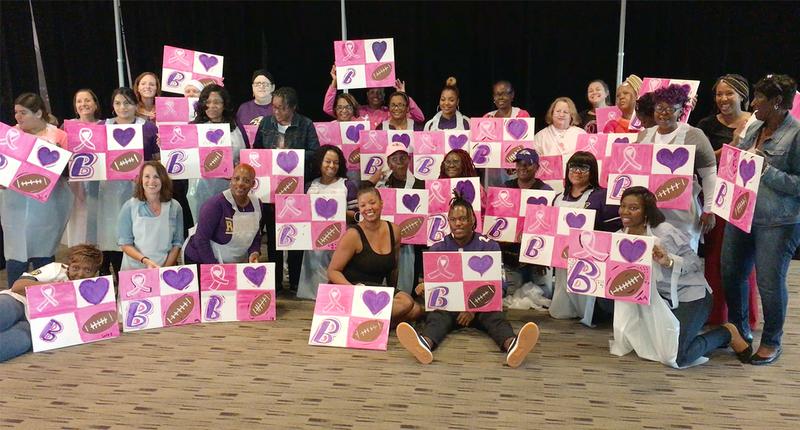 Group photo of cancer survivors and other participants in a sip-and-paint night with the Baltimore Ravens.