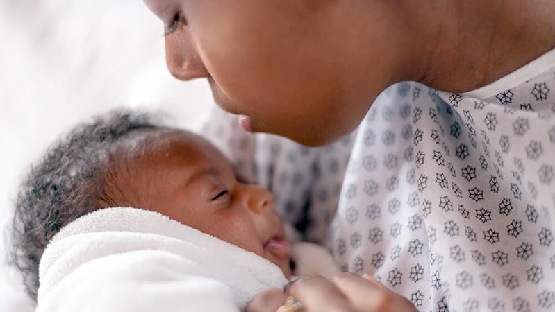 一位母亲和她刚出生的婴儿的特写照片。