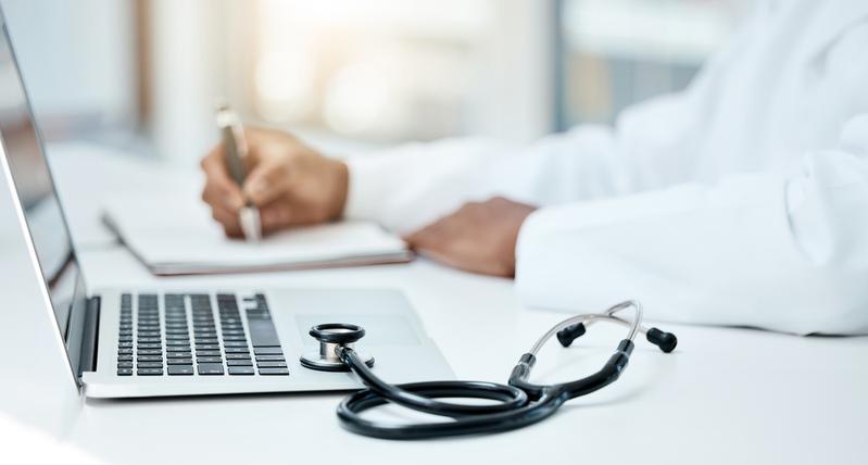 Close up photo of a stethoscope and a laptop computer.