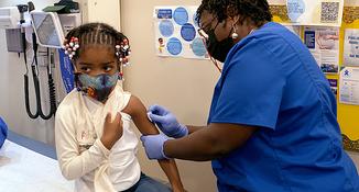 A young girl receives a vaccination at the mobile health center truck at MedStar Health.