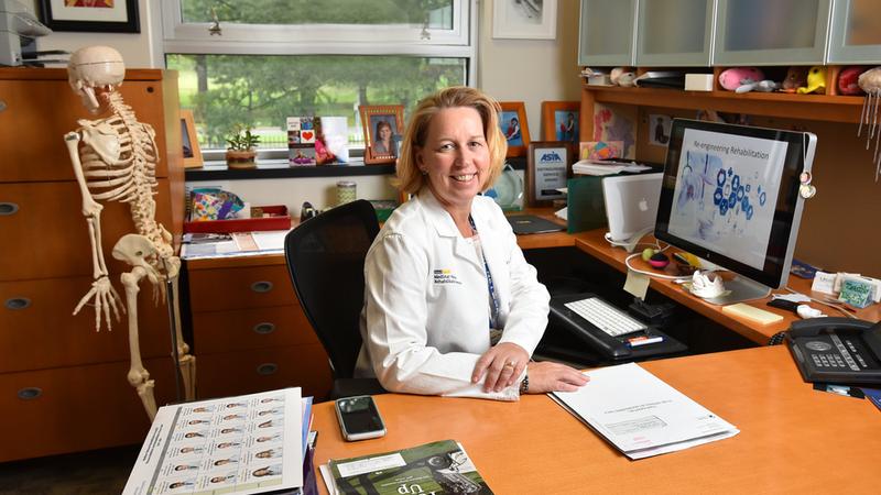 Dr Suzanne Groah sits at her desk and poses for a photo.