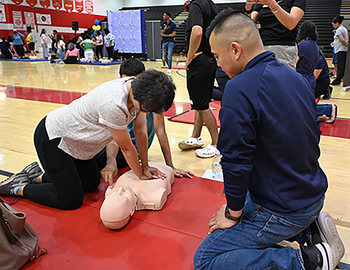 Experts from MedStar Health participate in a community health event to teach how to perform CPR and use an AED in an emergency.
