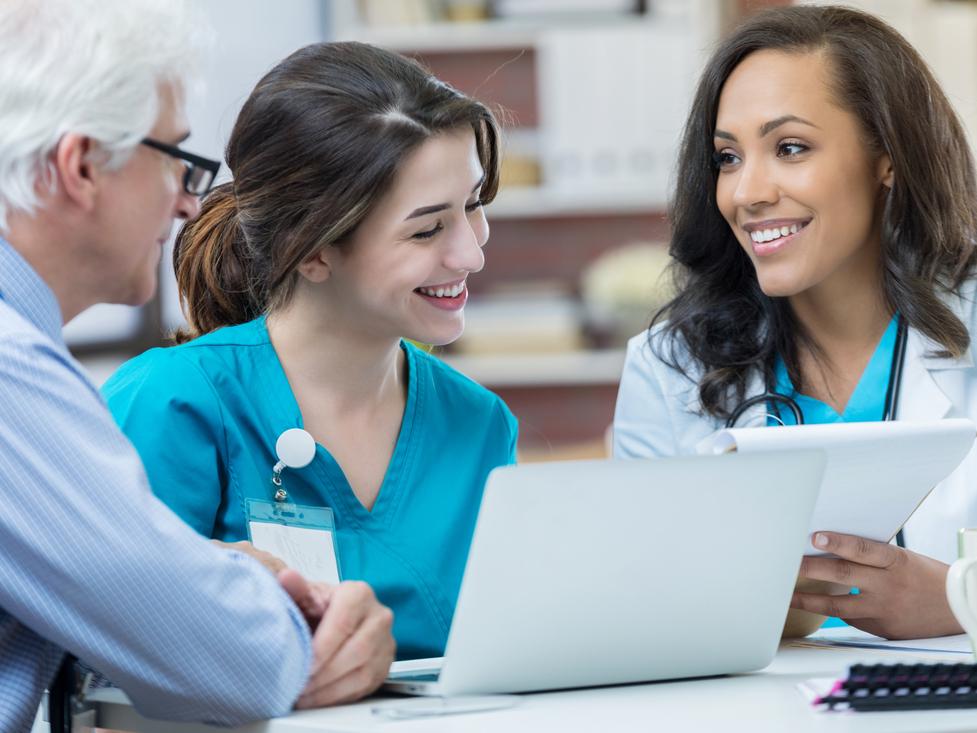 Female doctor discusses with staff during a meeting