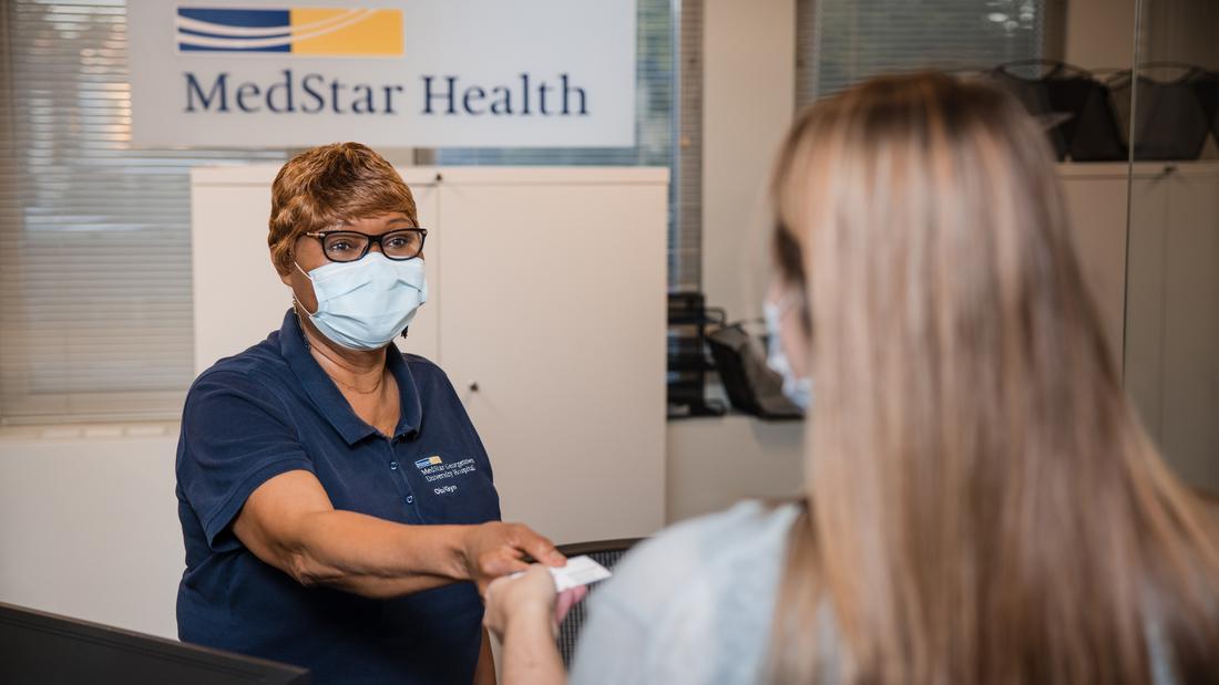 A receptionist welcomes a new patient to the MedStar Health ObGyn office at Glover Park.