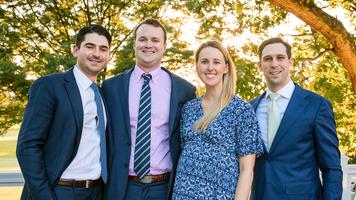 Four chief residents wearing white lab coats from the Orthopedic Residency Program in Washington DC stand together outdoors for a group photo.