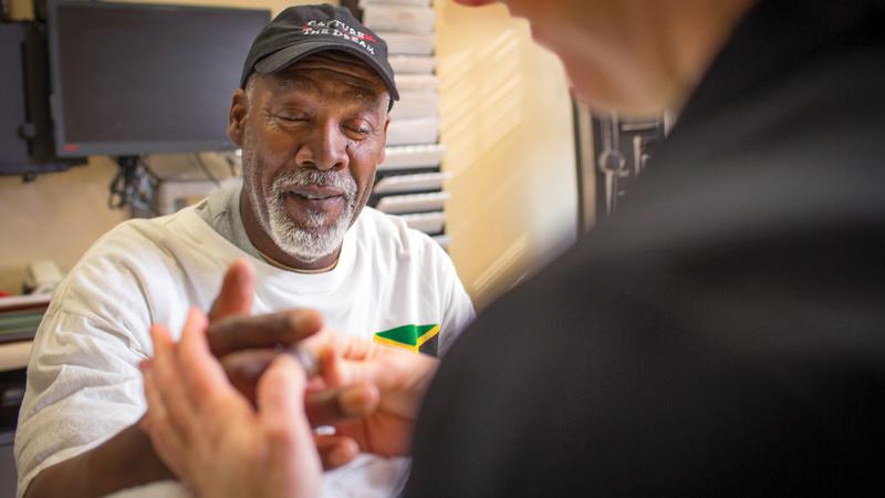 A MedStar Health physician examines a patient's hand during an office visit.