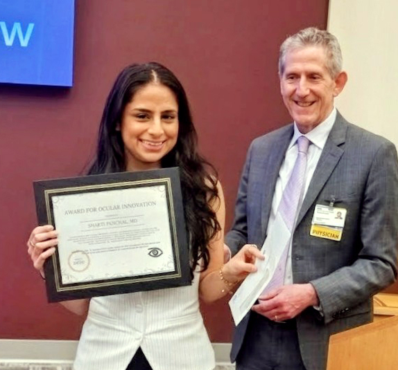 Bhakti Panchal receives an award from Dr. Jay Lustbader.