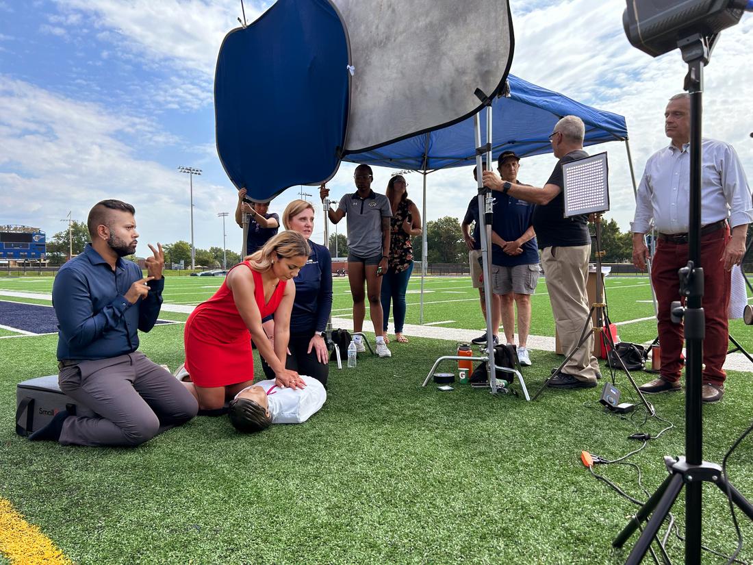 Miss District of Columbia practices CPR on a simulation mannequin during filming of MedStar Health's CPR training video.