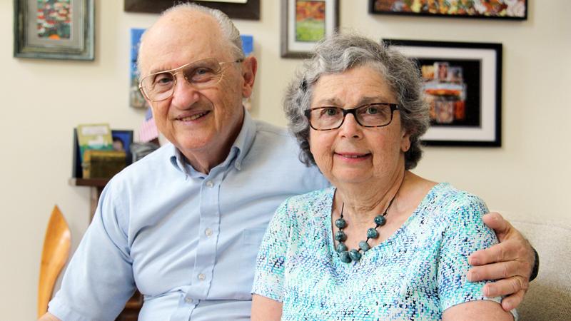 Bernard Matus sits with his arm around his wife Nancy in their home.