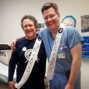 MedStar Health physician Sean Collins stands with his arm around patient Neal Bobys - the 1,000th patient to be treated for cancer using Cyberknife.