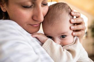 A mother holds her infant baby.