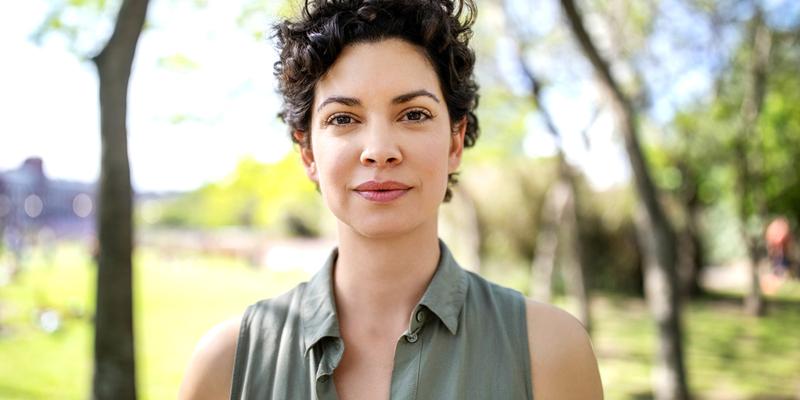 Portrait of a confident young woman standing at the park. Beautiful female in casuals looking at camera.