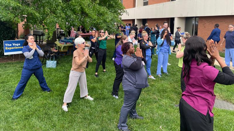 A group of MedStar Health associates participates in an outdoor yoga class.