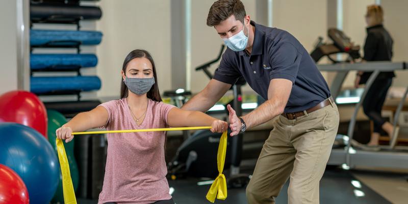 A male physical therapist works with a female patient during a rehabilitation session at a MedStar Health Physical Therapy location.