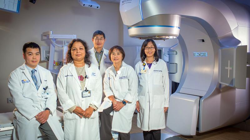 A team of MedStar Health radiologists stands in front of a large scanner machine.