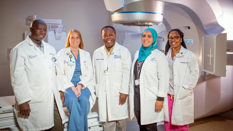 A team of radiation oncologists from MedStar Health pose for a photo in a treatment room.