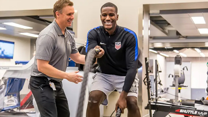 A personal trainer works with a professional athlete during a training session.