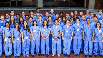 Team photo taken outdoors of the Anesthesiology Department at MedStar Georgetown University Hospital. All of the doctors are wearing blue scrubs.