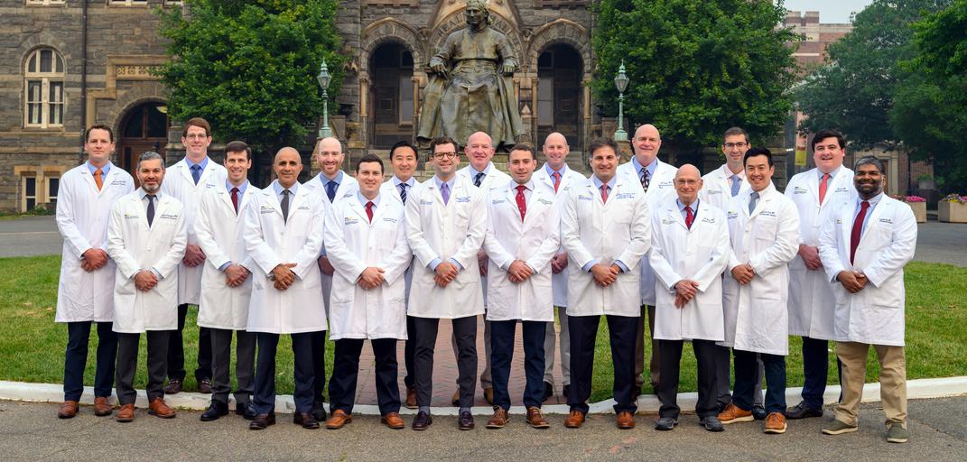 Faculty and chief residents wearing white lab coats from the Orthopedic Residency Program in Washington DC stand together outdoors for a group photo.
