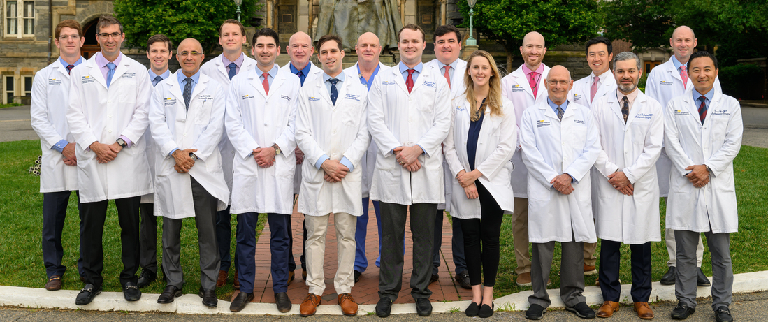 Faculty and chief residents wearing white lab coats from the Orthopedic Residency Program in Washington DC stand together outdoors for a group photo.