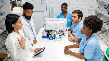 Pharmacy instructors teach a group of pharmacy students in a clinical setting.