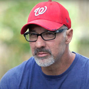 Photo of a man wearing a red baseball cap, who underwent remote patient monitoring while recovering from COVID-19.