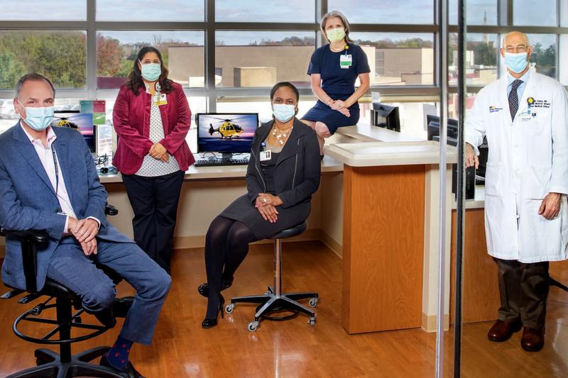 The leadership team for the Safe Babies Safe Moms program poses for a photo in an office setting. All 5 people are socially distanced and wearing masks.