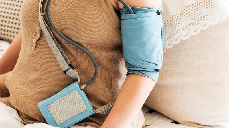 Close up photo of an ambulatory blood pressure monitor on a woman in her home.