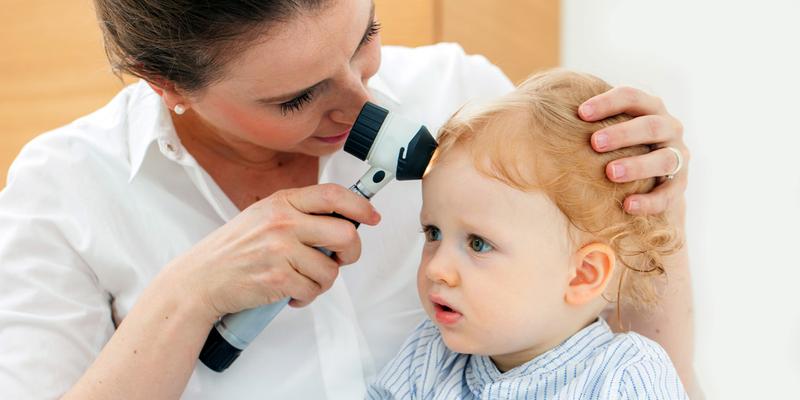 A doctor checks the skin of a young child during an office visit.