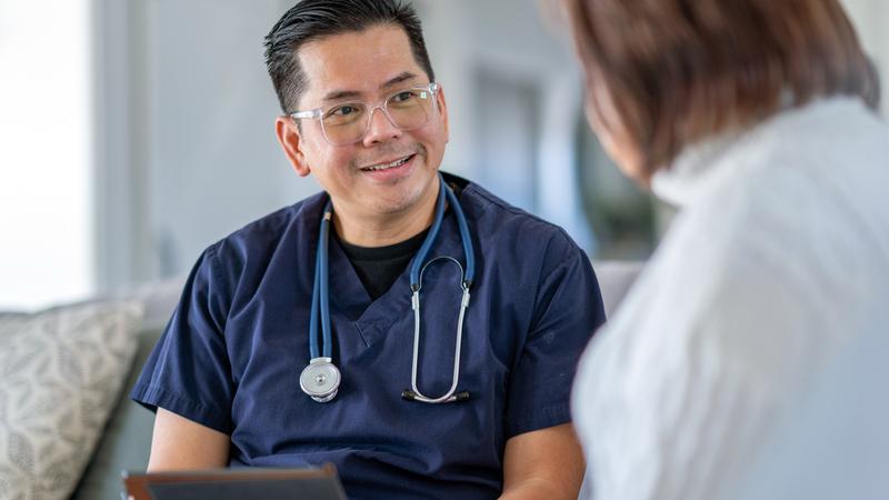 A healthcare professional consults with a senior woman.