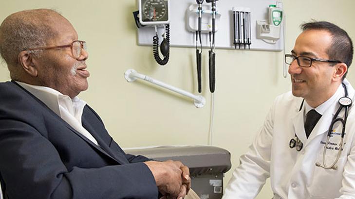 Dr George Hennawi consults with a patient in a clinical setting.