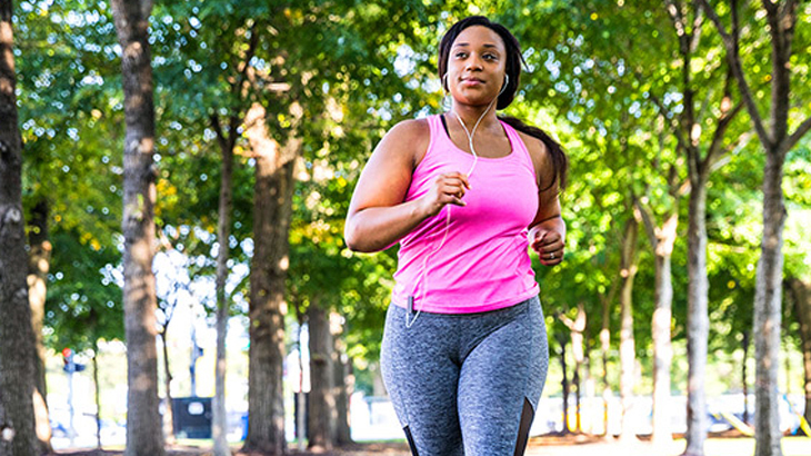 A young woman runs in an park.