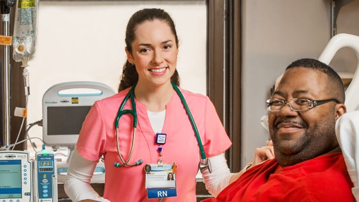 A nurse, wearing pink scrubs, and a patient pose for a photo at MedStar Health.